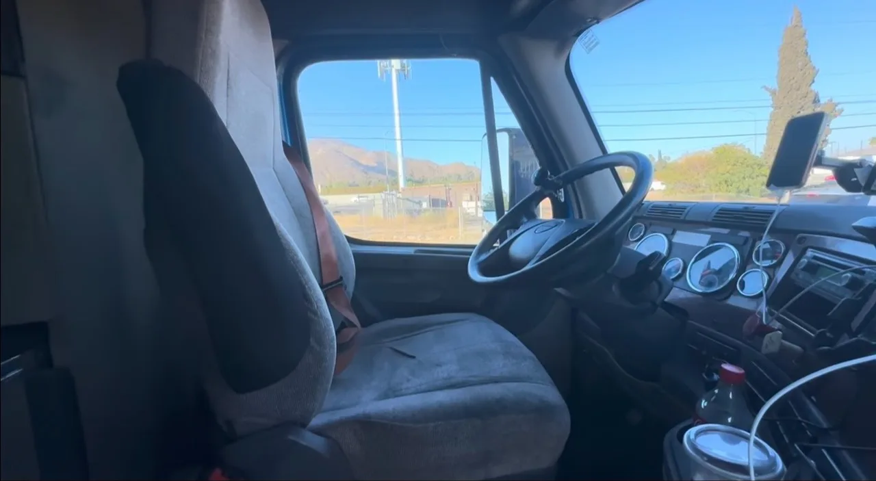 Inside a truck cab with a phone mounted on the dash