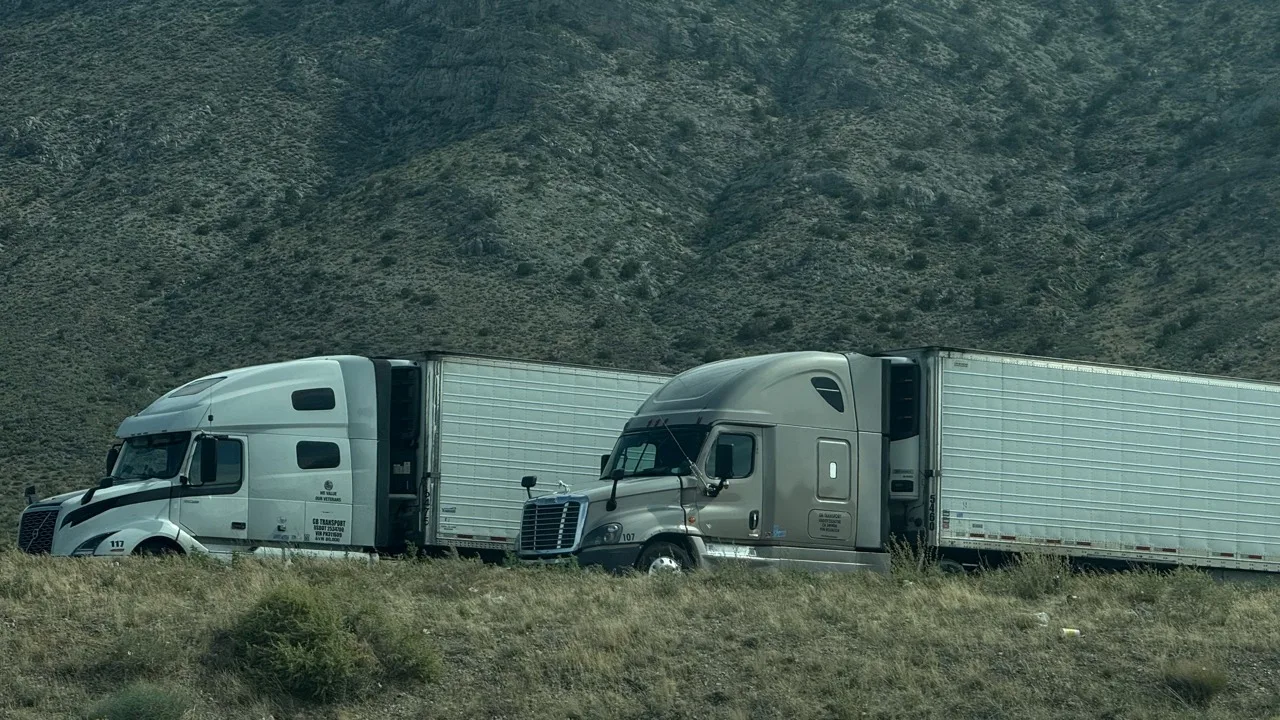 Two reefer trucks on a mountain highway